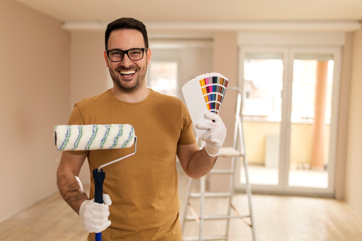 Young man painting apartment